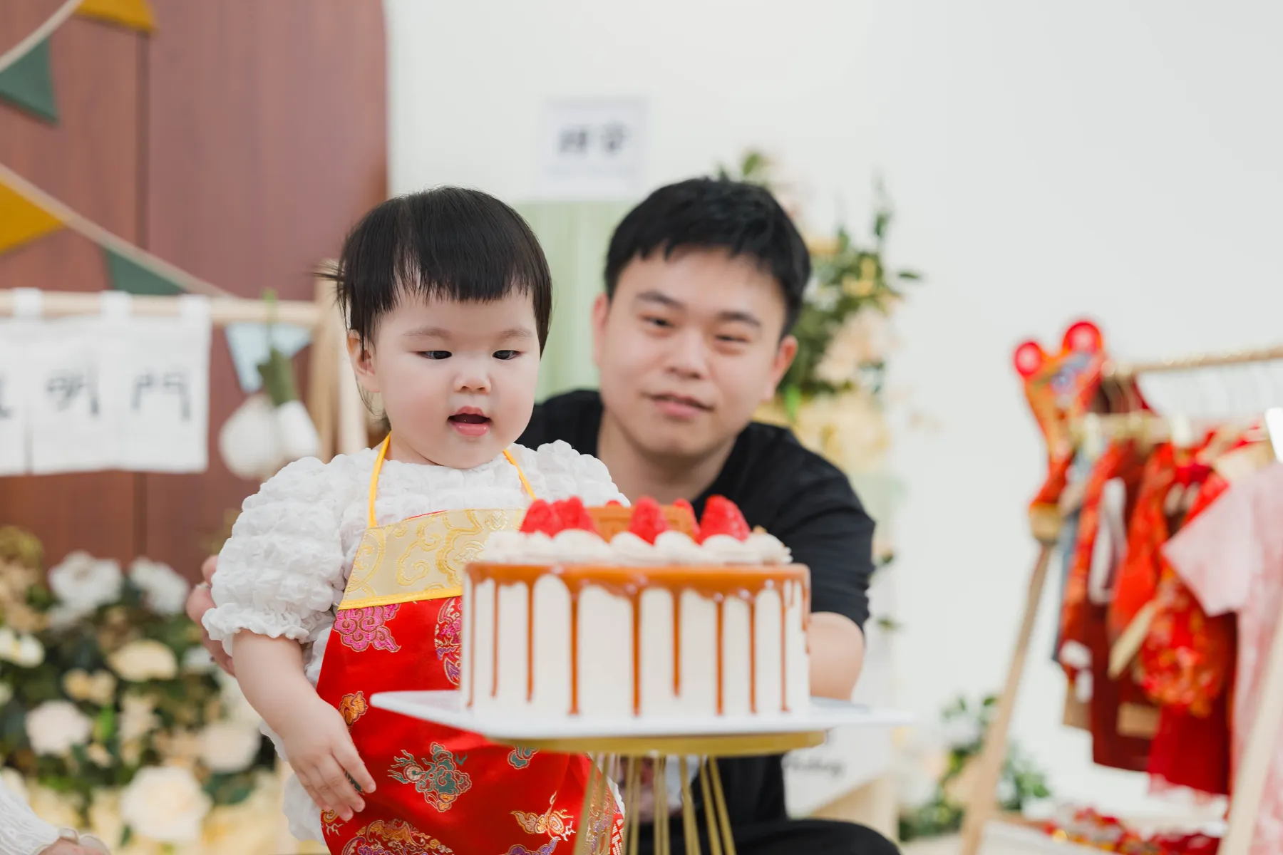 爸爸抱著寶寶看周歲蛋糕