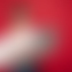 photographie-jeune-femme-brune-souriante-tenant-un-ordinateur-portable-sur-fond-rouge