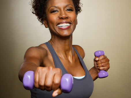 Middle-Aged Healthy female lifting weights and performing strength training.