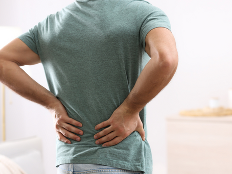 A man holding onto his low back due to pain.