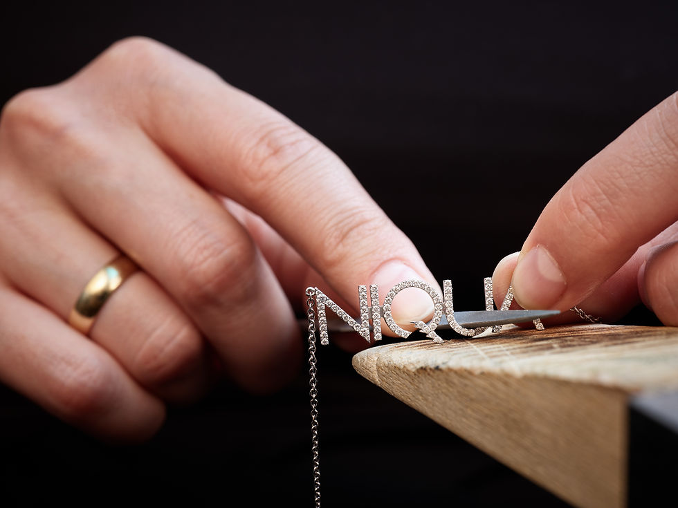Fine craftsmanship in action – a jeweller delicately refines a diamond-set NIQUA pendant with precision tools. A symbol of tr