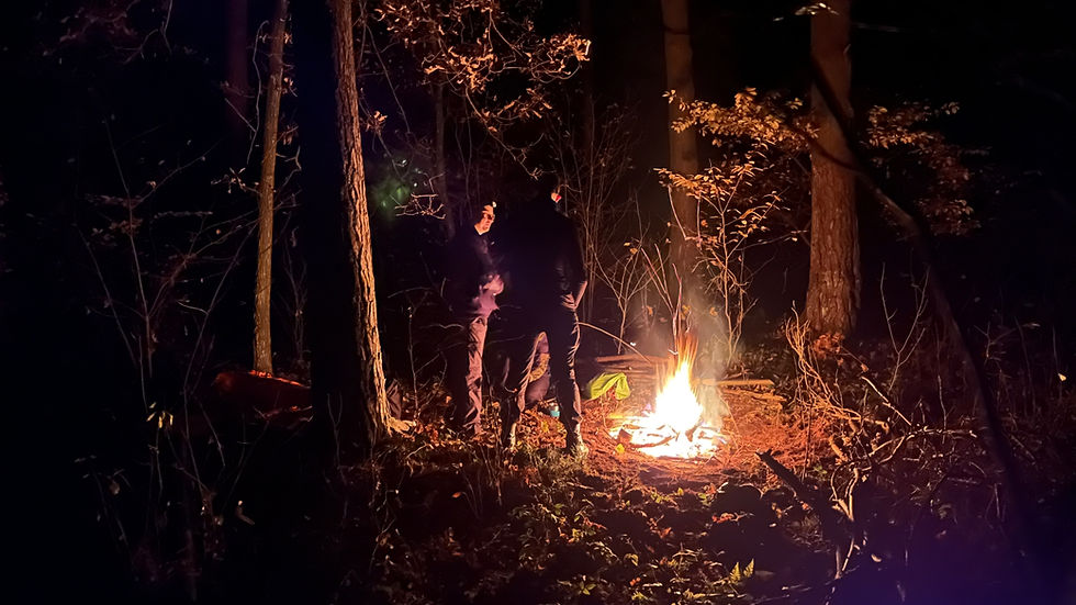 Ognisko płonie, a dwóch kursantów omawia szczegóły zająć na kolejny dzień