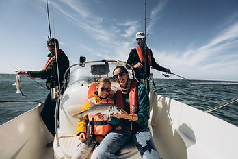 Guide de pêche et client en action lors d'une sortie pêche en mer à Calais