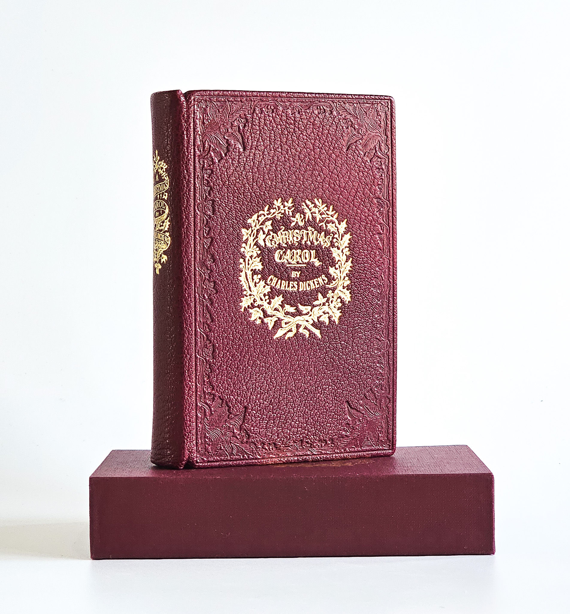 Upper board of the 1978 David Paradine facsimile of A Christmas Carol, burgundy leather blocked in gilt with a holly wreath