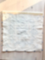 Quilted batting square with pins on three sides.