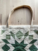 A green and cream tote bag with a cream webbed handle sewn onto the top.