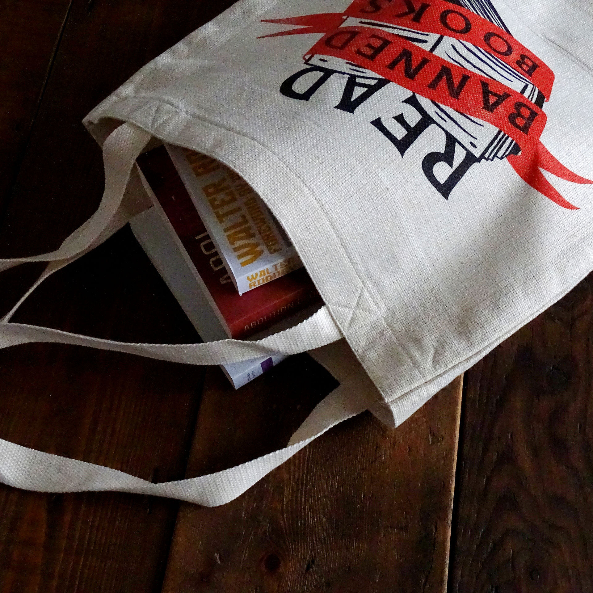 White tote bag with the slogan "Read Banned Books" written across it