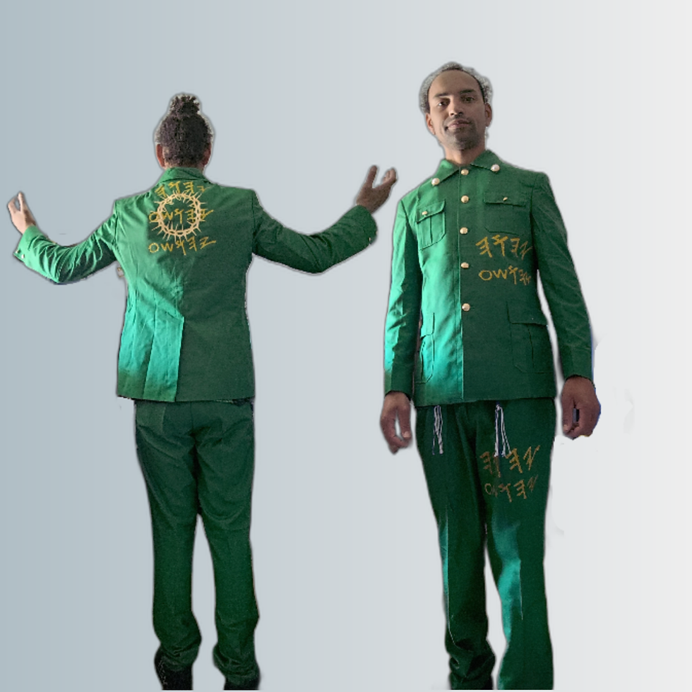 Two men in green suits with gold embroidery and text posing for a photo.