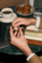 Vintage Cartier-Armbanduhr aus dem Bucherer Certified Pre-Owned Sortiment, in den Händen eines Mannes über Notizbuch, Kaffee und Lederaccessoires betrachtet.