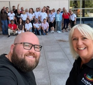 Pebble People Development facilitators Sonya and Cameron taking a selfie with the Hable employee team gathered in the background outside St. George's Park.