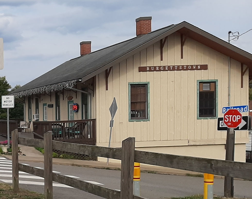 The historic Burgettstown train station building by a road.