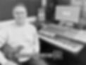 Michael Coltham, Creative Director sat in a music studio holding a PRS electric guitar.