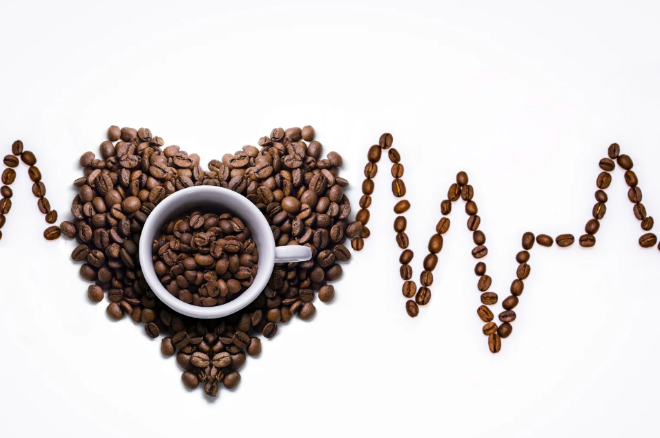 cup full of coffee on coffee beans