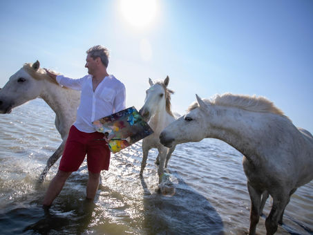 Painter Andrew Manaylo standing among horses, reflecting on 2026 – the Year of the Horse