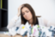 Woman looking upset surrounded by paper