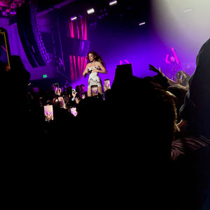 People holding up cell phones at a Noa Kirel concert.