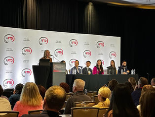 Individual speaking at a podium at a conference