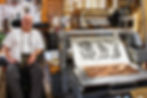 man in wheelchair standing in front of printed artwork