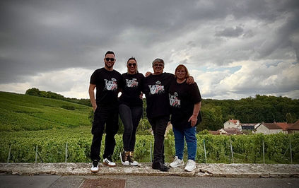 Quatre personnes devant un vignoble.