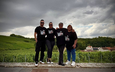 Quatre personnes devant un vignoble.