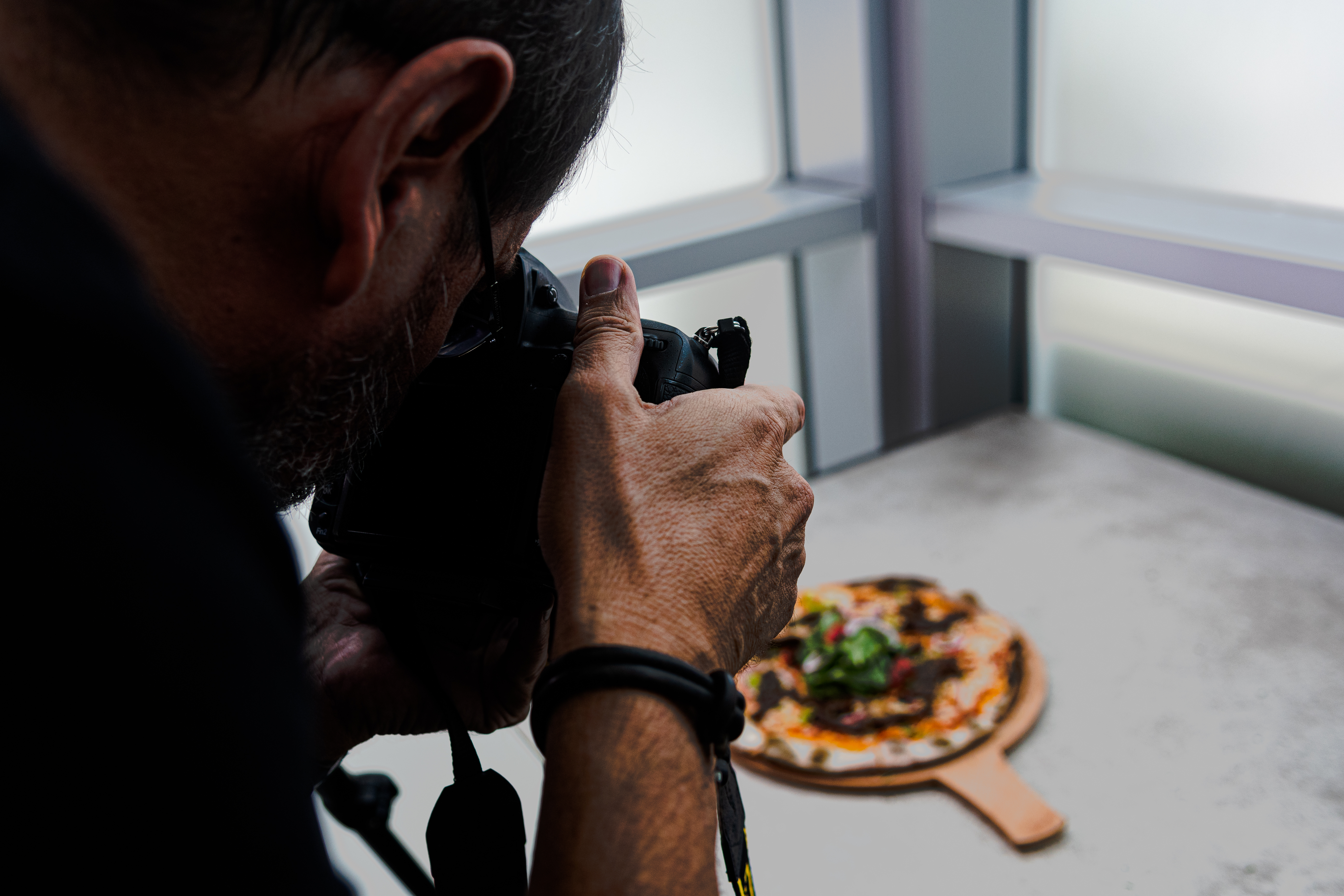 high-angle-shot-person-taking-photo-pizza-table.jpg