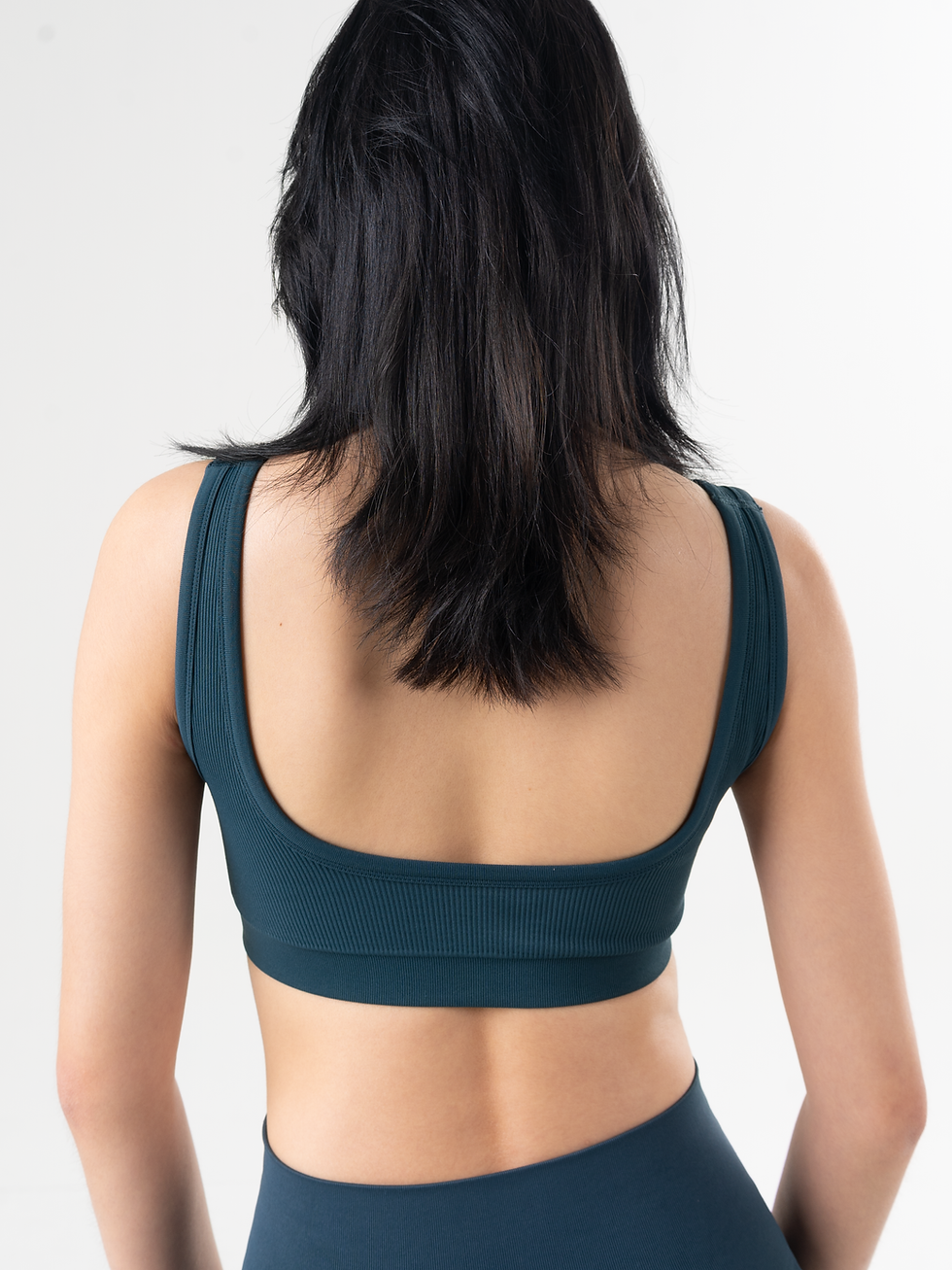 Seamless activewear bra top with square neckline and low back in Monsoon blue, close up back view