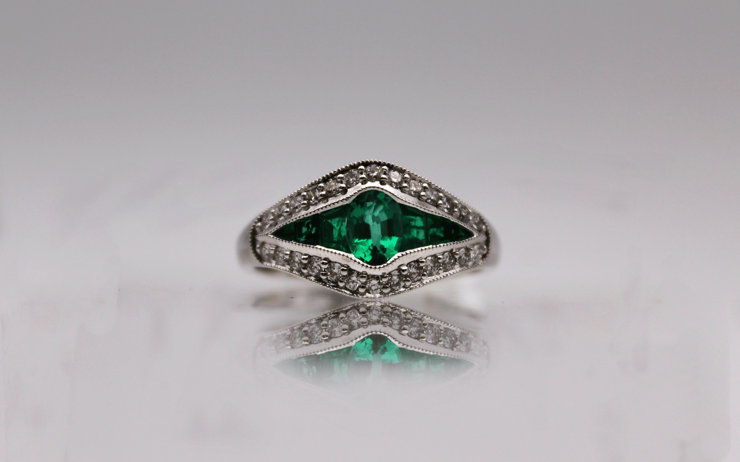 a white gold ring with an emerald and diamonds