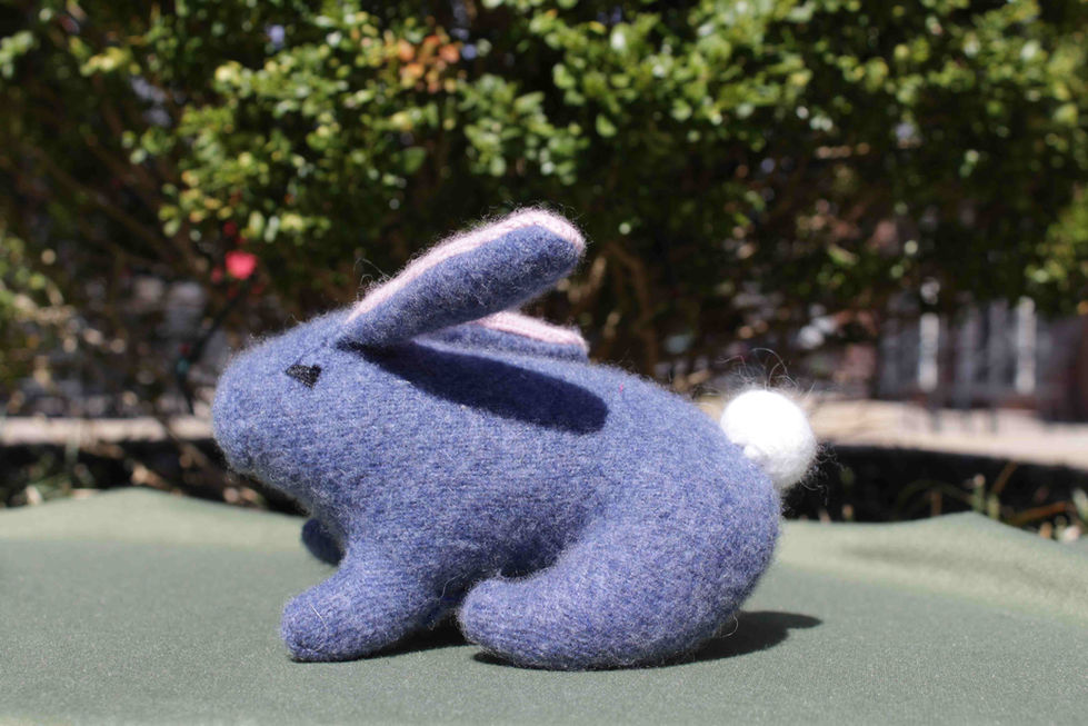 a blue stuffed rabbit with pink ears and a white tail