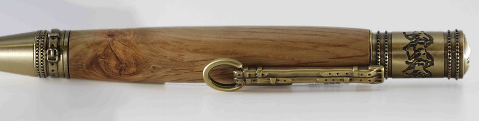 a close up of a brass buckle clip on wood pen