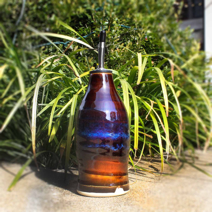 a brown and blue ceramic bottle with a black cap