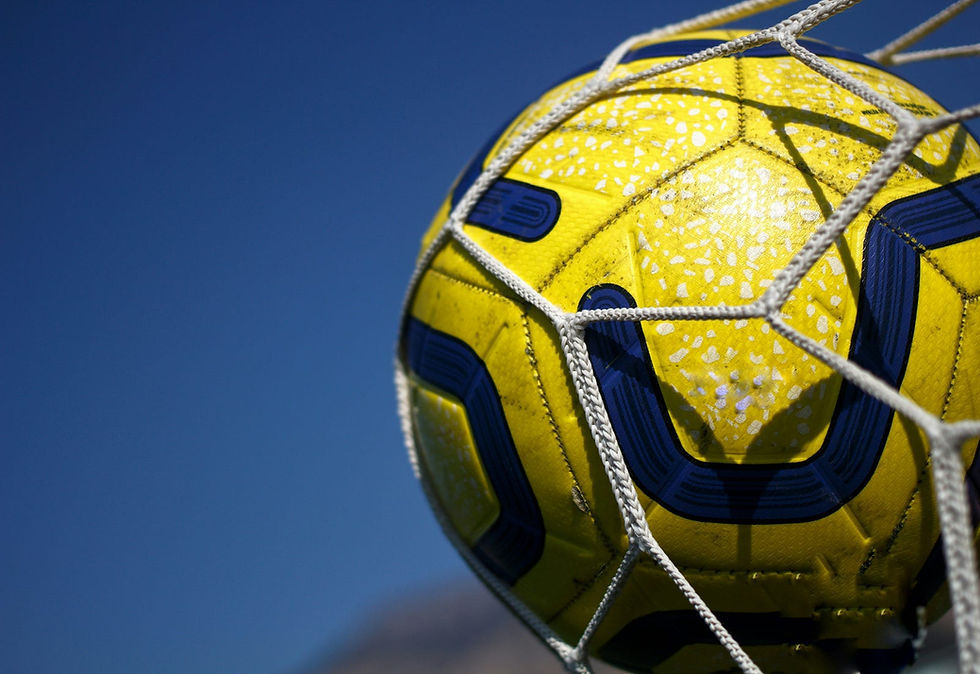 A vibrant yellow and blue soccer ball caught in the net against a clear blue sky, symbolizing a triumphant goal on a sunny day.