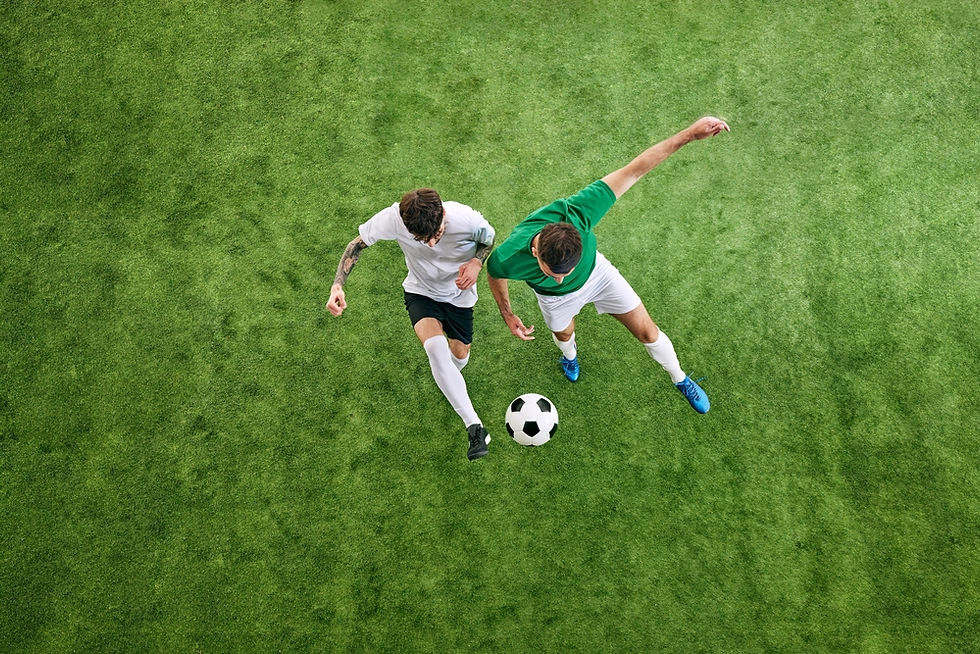 Two soccer players in opposing jerseys vie for possession of the ball on a vibrant green field, showcasing intense competition and skill.