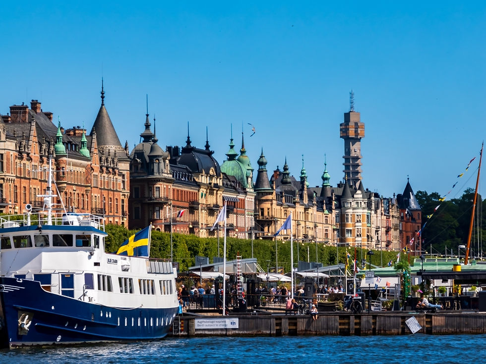 A picturesque scene of Stockholm's vibrant waterfront, featuring a traditional Swedish vessel adorned with the national flag. The backdrop showcases the city's iconic architecture under a clear blue sky.
