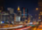 The vibrant Atlanta skyline glows against the night sky, with bustling light trails from traffic highlighting the city's dynamic energy.