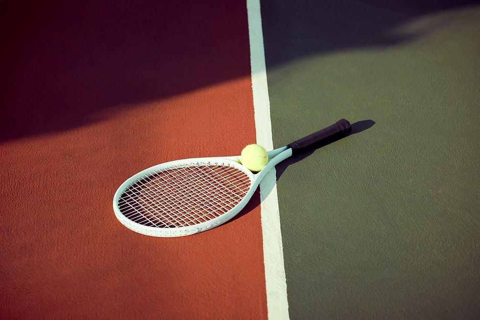 A tennis racket and ball lie across the dividing line on a sunlit court, symbolizing a moment of pause in the game.