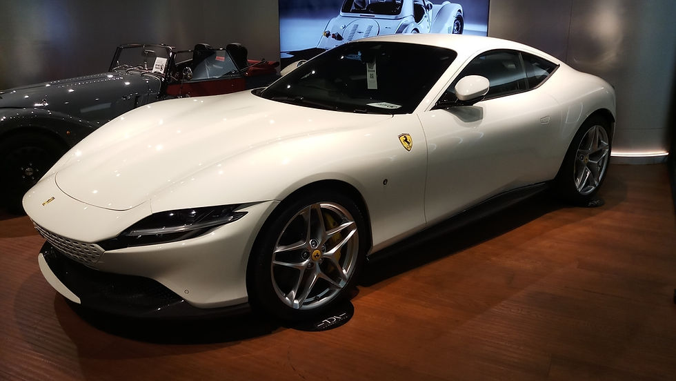 A sleek white sports car elegantly displayed in a modern showroom, highlighting its aerodynamic design and luxurious appeal.