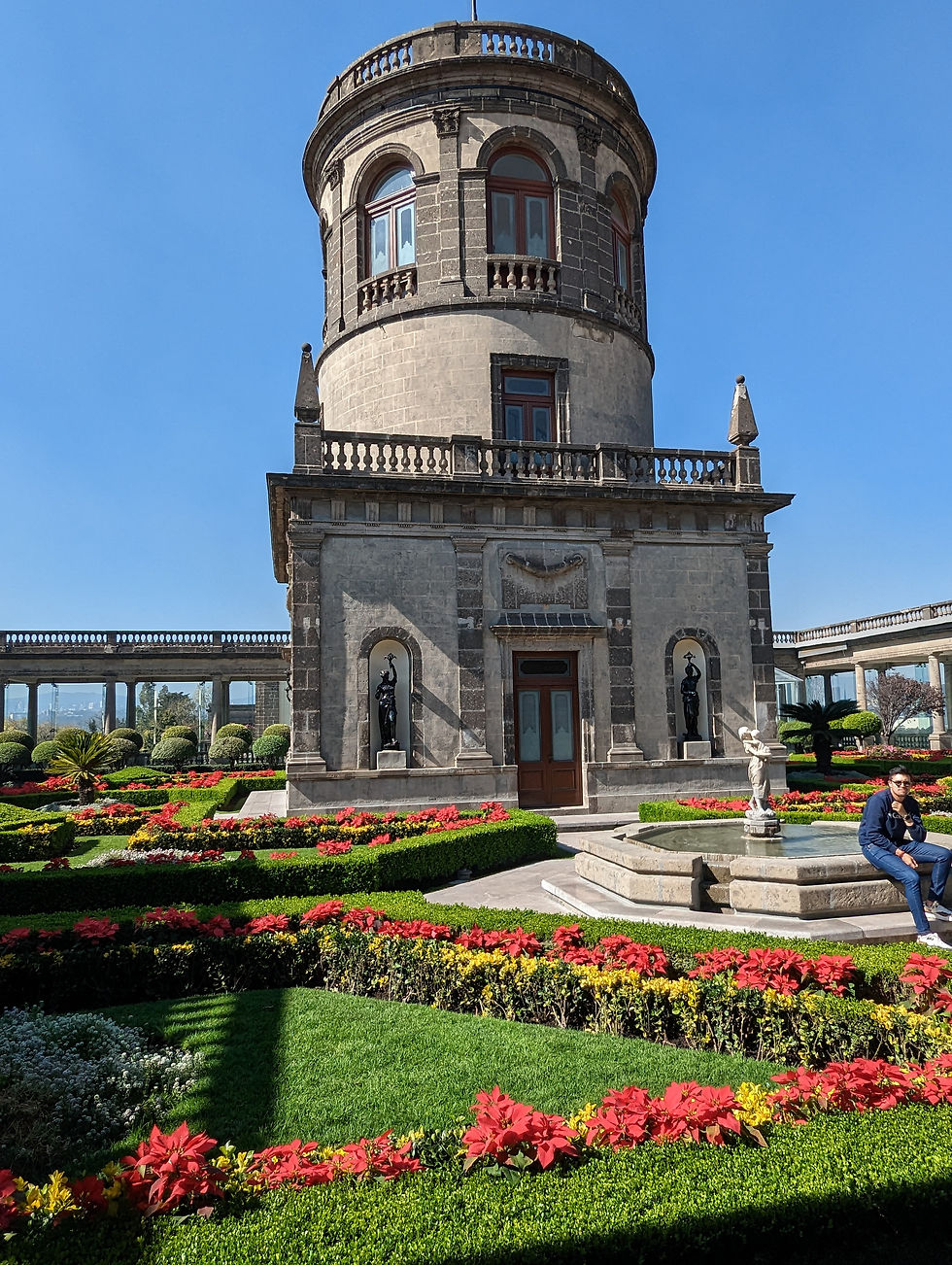 stone tower behind geometric garden at Castillo Chapultepec