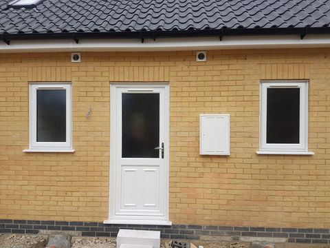 White PVC-U back door with large frosted glazed panel on a yellow brick house.