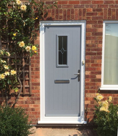 Grey composite front door with vertical glazing and letterbox