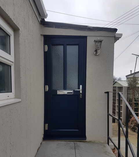 Dark blue PVC-U entrance door with three frosted glass panels and chrome furniture.