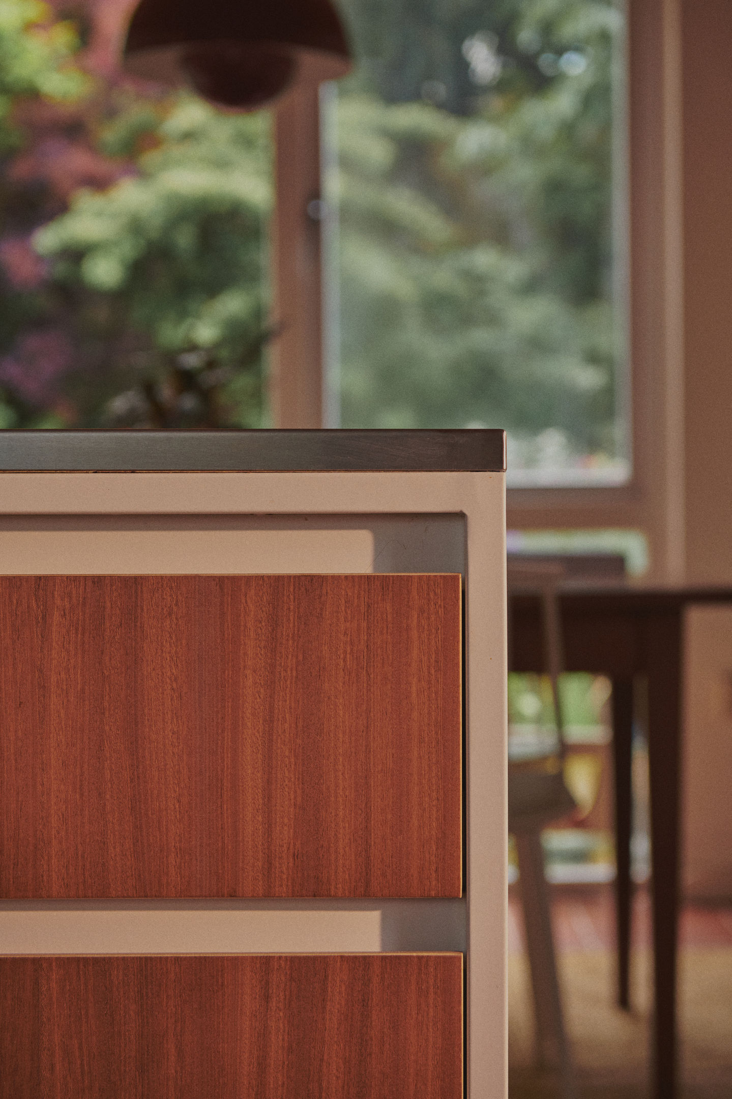 Mid-century kitchen with RAL 9010 steel frames, Sapele veneer, reeded glass wall units, stainless steel worktop, teak ceiling panels, and vintage-style tiles.