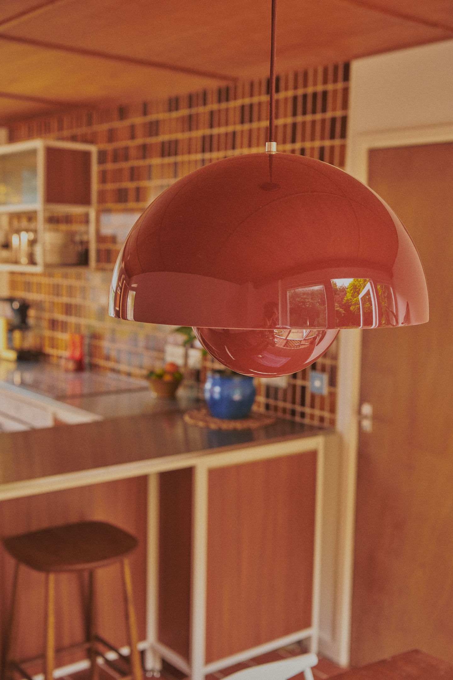 Mid-century kitchen with RAL 9010 steel frames, Sapele veneer, reeded glass wall units, stainless steel worktop, teak ceiling panels, and vintage-style tiles.