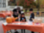 A HopeWell family carving pumpkins during a Halloween event.jpg