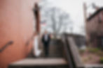 Bride and groom on outdoor steps for portraits on wedding day