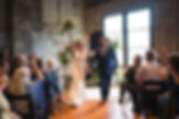 Bride and groom just married floral backdrop large windows venue