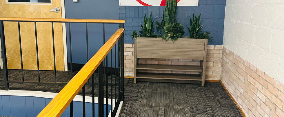 A hallway with carpet and a wall art featuring the Columbus City School logo