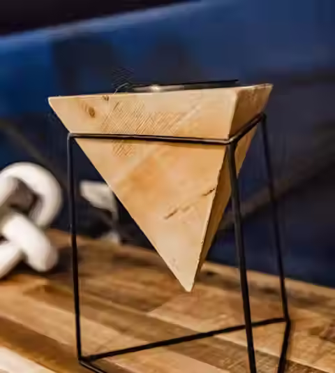 A closeup of a small wooden pyramid as artwork on a table