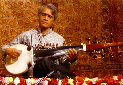 K. Sridhar playing Sarod in front of flower mala