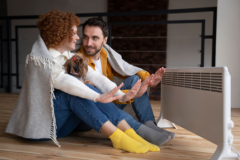 full-shot-couple-warming-up-their-hands-with-heater.jpg