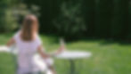 Donna seduta in giardino con un calice in mano, in un momento di quiete all’aperto